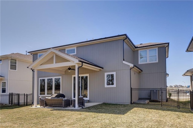 rear view of property featuring a yard, a ceiling fan, and fence