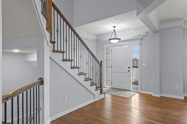 entrance foyer featuring ornamental molding, baseboards, and hardwood / wood-style floors