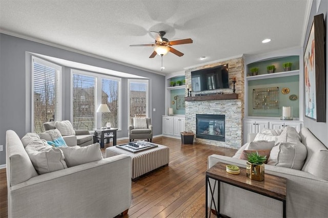 living area with a textured ceiling, ornamental molding, and hardwood / wood-style flooring