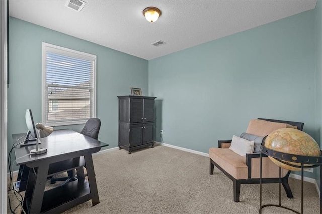 office space featuring light colored carpet, baseboards, visible vents, and a textured ceiling