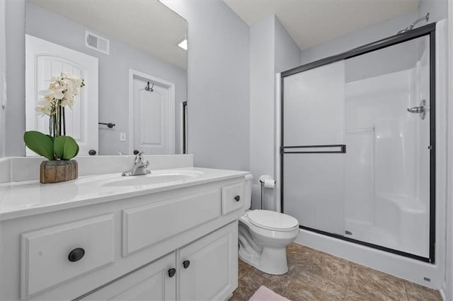 bathroom featuring visible vents, toilet, a stall shower, and vanity