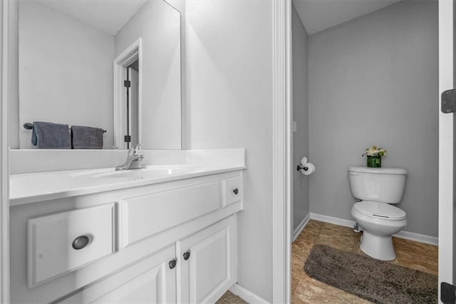 bathroom featuring vanity, toilet, and baseboards