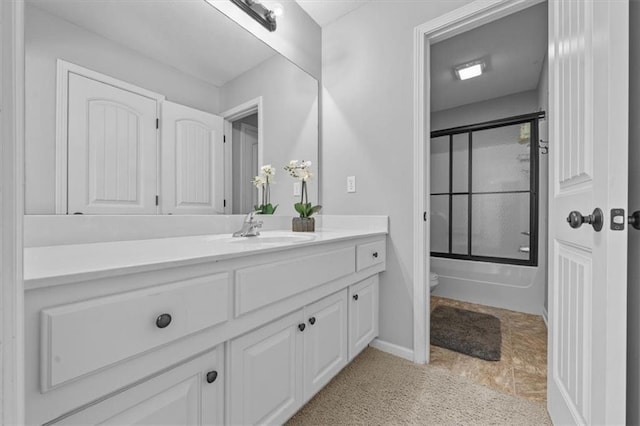 bathroom with vanity, toilet, and shower / bath combination with glass door