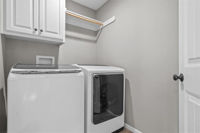 clothes washing area with cabinet space, baseboards, and washer and clothes dryer