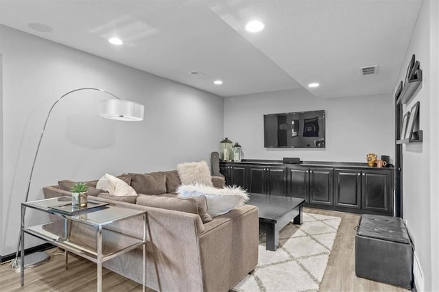 living room featuring visible vents, recessed lighting, and light wood-style floors