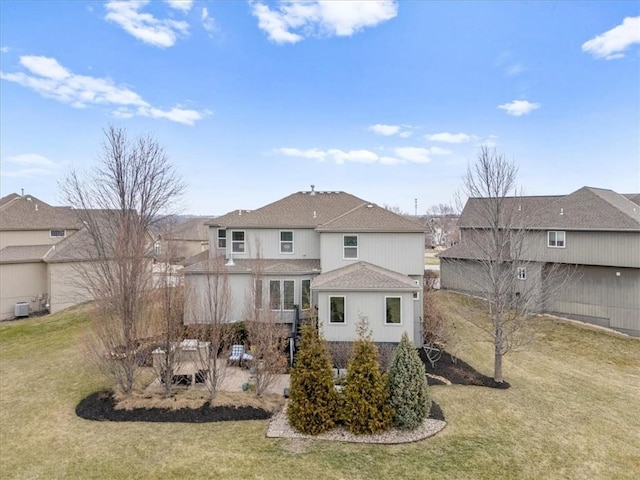 back of house featuring a lawn, central AC unit, and a shingled roof