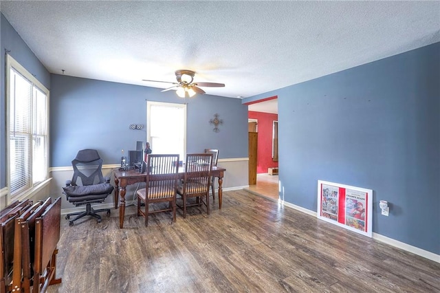 dining area with a ceiling fan, a textured ceiling, baseboards, and wood finished floors