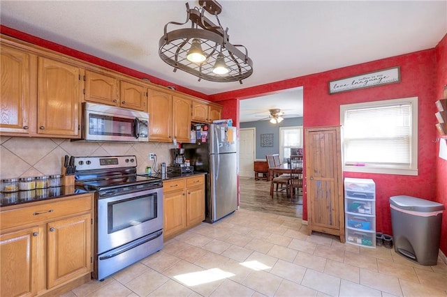 kitchen with dark countertops, a healthy amount of sunlight, and appliances with stainless steel finishes