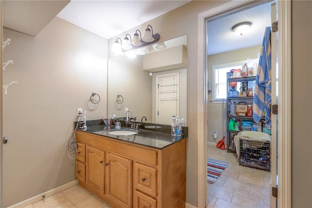 bathroom featuring vanity, baseboards, and tile patterned floors