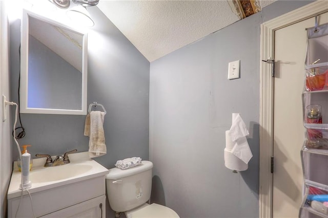 half bath featuring toilet, lofted ceiling, a textured ceiling, and vanity