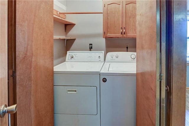 washroom featuring washer and dryer and cabinet space