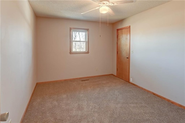 empty room featuring a ceiling fan, carpet, baseboards, and a textured ceiling