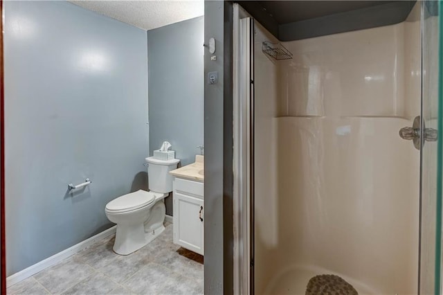 bathroom featuring vanity, toilet, baseboards, and walk in shower