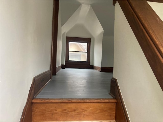 staircase featuring wood finished floors and baseboards