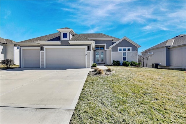 view of front of home with driveway, a front lawn, and an attached garage