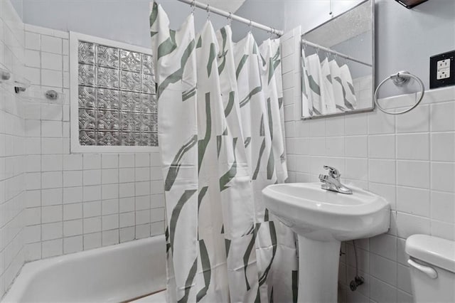 bathroom with toilet, shower / bath combo with shower curtain, tile walls, and decorative backsplash