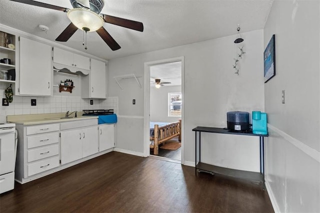 kitchen with dark wood-style flooring, open shelves, light countertops, white cabinetry, and a sink