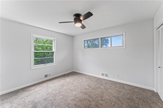 unfurnished bedroom with carpet floors, baseboards, a closet, and a ceiling fan