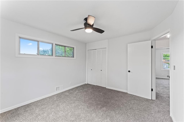 unfurnished bedroom with carpet floors, a closet, baseboards, and ceiling fan