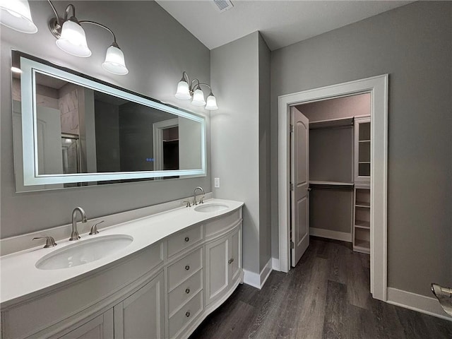 full bathroom with wood finished floors, baseboards, and a sink