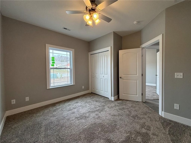 unfurnished bedroom with carpet, baseboards, visible vents, a ceiling fan, and a closet