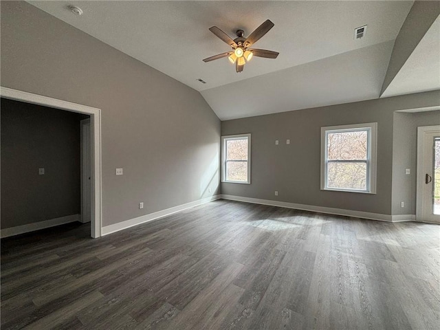 spare room featuring visible vents, wood finished floors, a ceiling fan, and vaulted ceiling