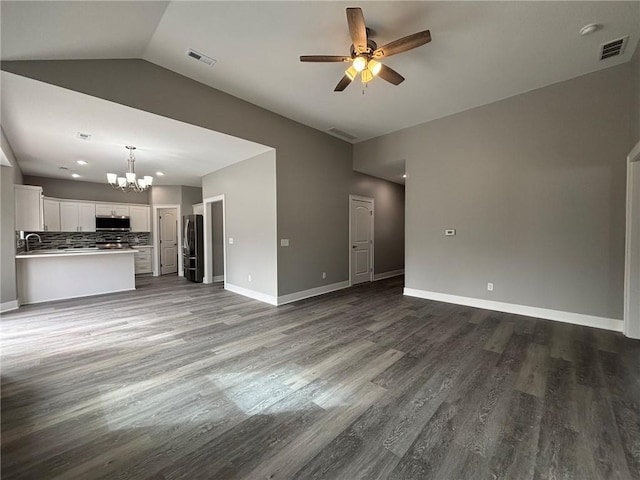 unfurnished living room featuring visible vents, dark wood-style floors, and ceiling fan with notable chandelier