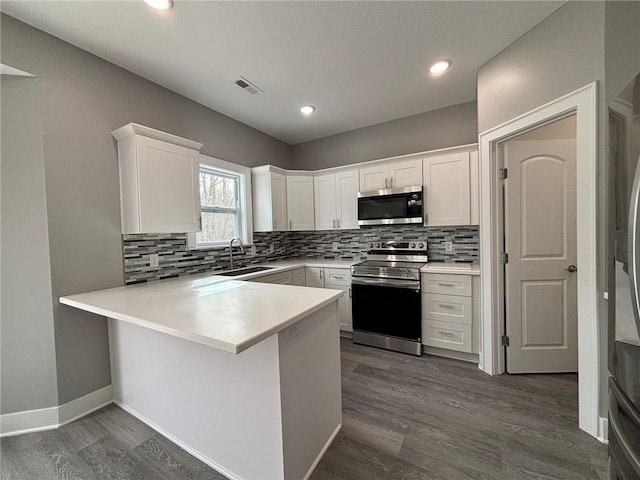 kitchen featuring tasteful backsplash, visible vents, appliances with stainless steel finishes, white cabinets, and a sink