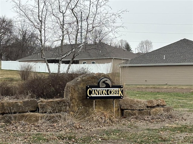 community / neighborhood sign featuring fence