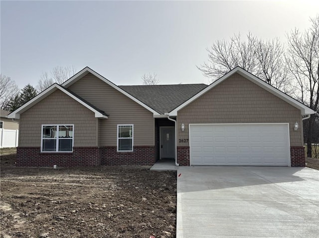 single story home featuring driveway, brick siding, and an attached garage