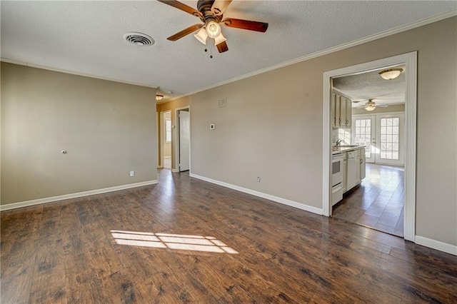 unfurnished room with baseboards, visible vents, dark wood finished floors, crown molding, and a textured ceiling