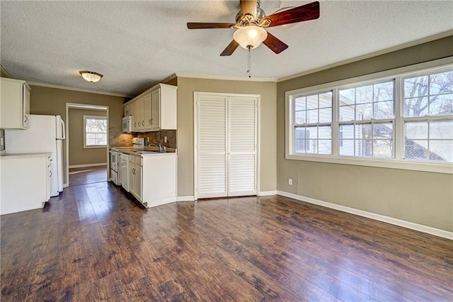 kitchen featuring crown molding, dark wood finished floors, tasteful backsplash, a sink, and white appliances