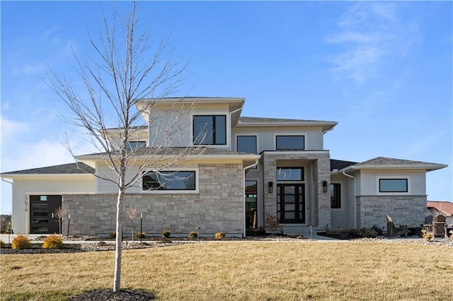 view of front facade featuring a garage, stone siding, and a front yard