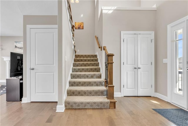 entryway with baseboards, wood finished floors, and stairway