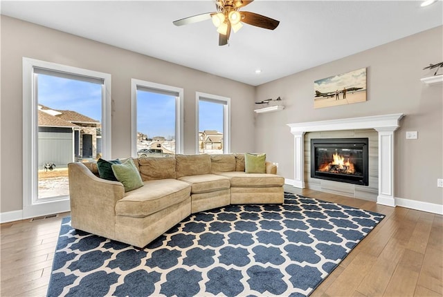 living room featuring ceiling fan, visible vents, a healthy amount of sunlight, and hardwood / wood-style flooring