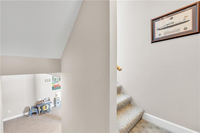 staircase featuring baseboards, carpet flooring, and visible vents