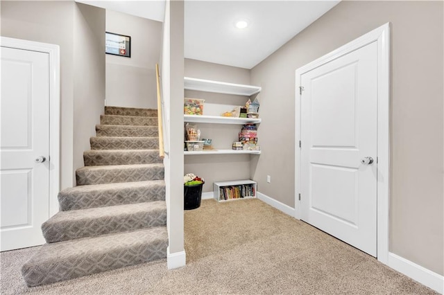 staircase with baseboards, recessed lighting, and carpet