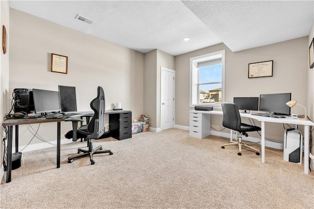 carpeted office featuring a textured ceiling, baseboards, and visible vents