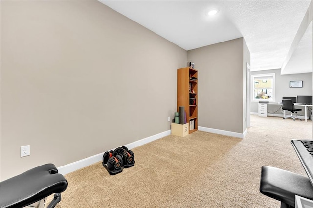 exercise room with baseboards and carpet