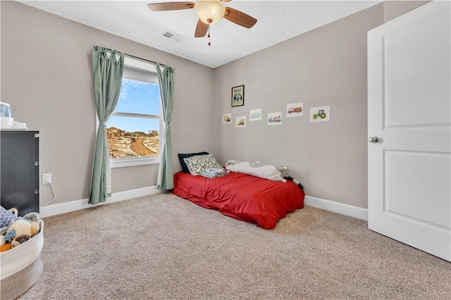 carpeted bedroom featuring baseboards, visible vents, and ceiling fan