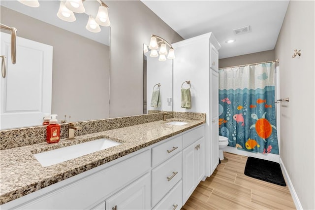 bathroom featuring visible vents, a sink, double vanity, and toilet