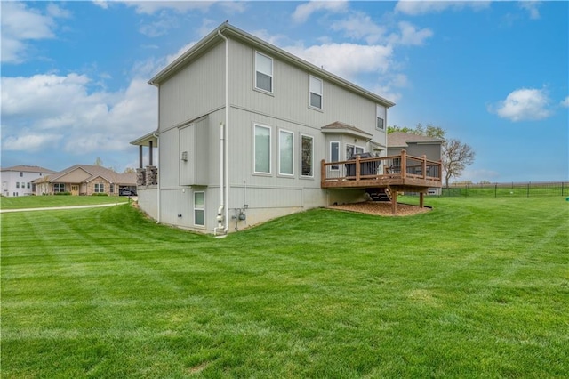 rear view of property featuring a lawn and a deck