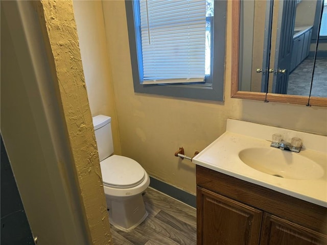 bathroom with vanity, toilet, and baseboards