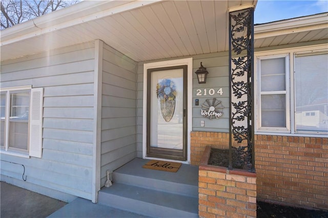 doorway to property with brick siding