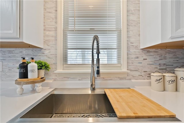 interior details with white cabinetry and decorative backsplash