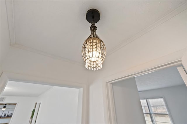 details with an inviting chandelier and ornamental molding