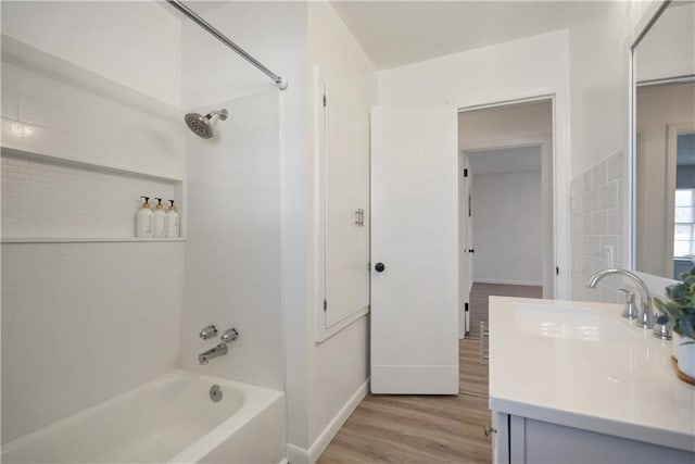 full bath with baseboards, shower / washtub combination, wood finished floors, and vanity