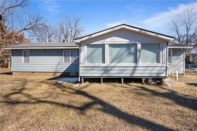 rear view of house with a yard, crawl space, and roof with shingles