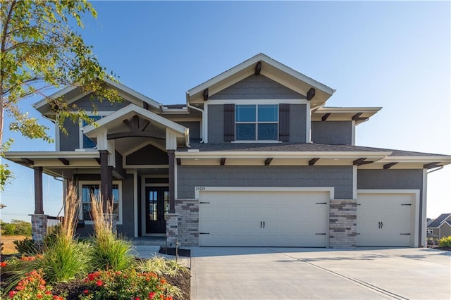 craftsman house with an attached garage, concrete driveway, and stucco siding