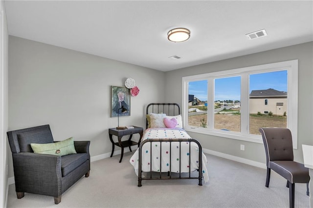 bedroom with light carpet, visible vents, and baseboards